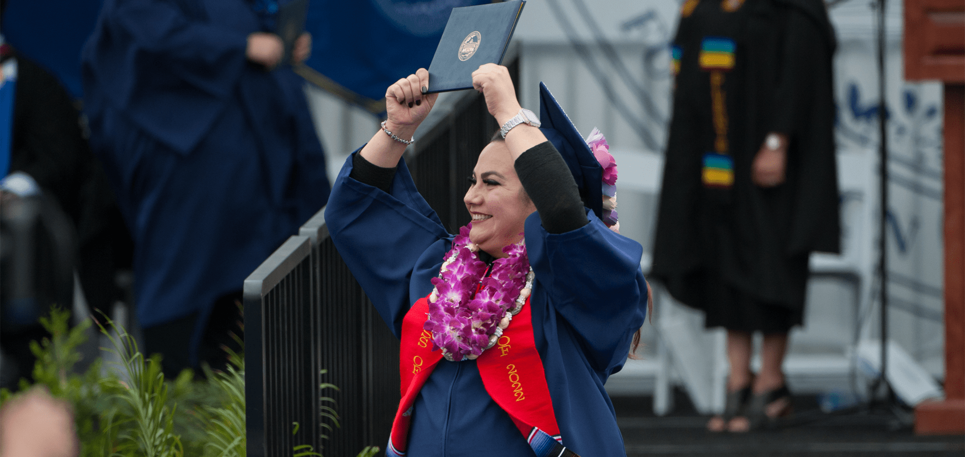fullerton college graduate lifts degree up in celebration