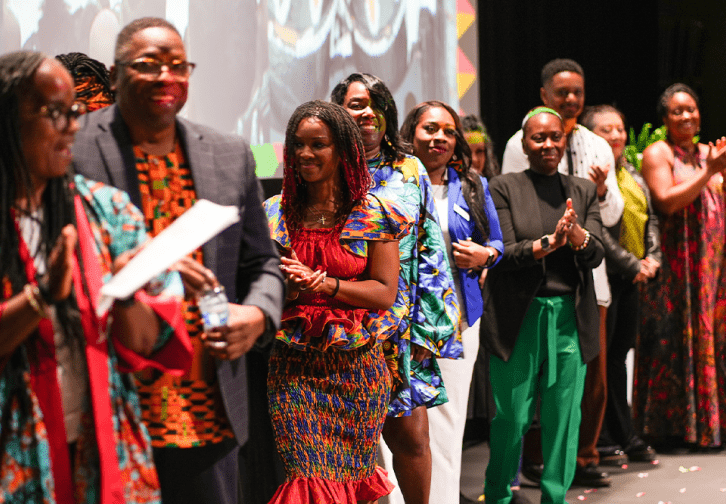 The ADES 2024 attendees being applauded onstage.