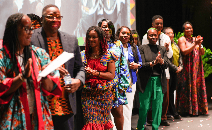 The ADES 2024 attendees being applauded onstage.