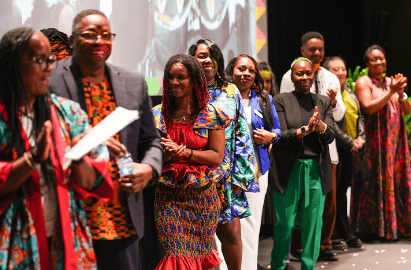 The ADES 2024 attendees being applauded onstage.